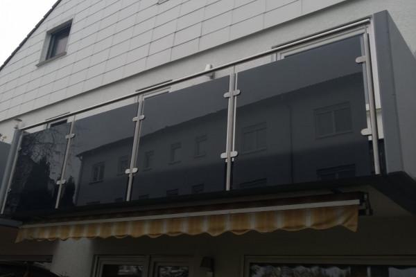 Balkongeländer mit dunklen Glasscheiben